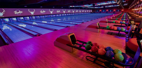 Ball returns and bowling lanes with 'LUST' written on the wall