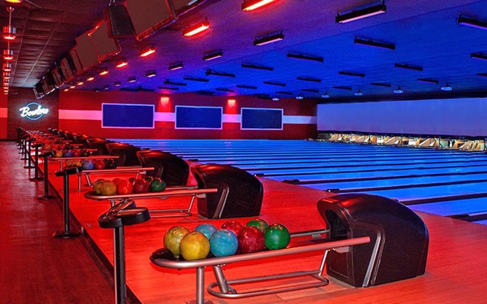 Bowling lanes with colorful bowling balls on ball returns