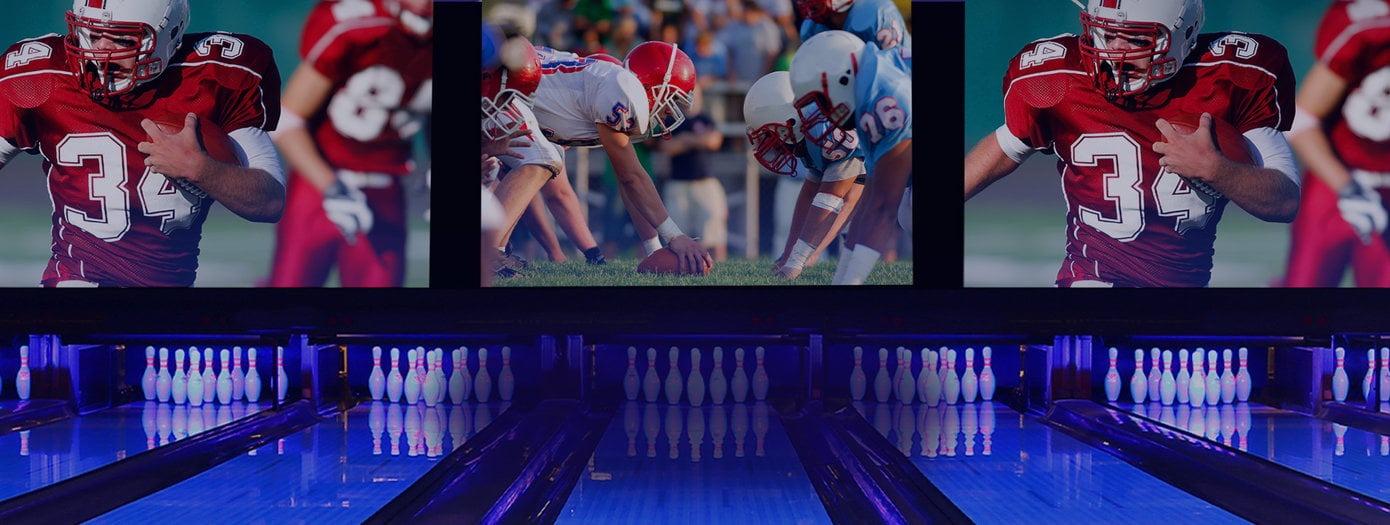 Football being displayed on screens above bowling lanes