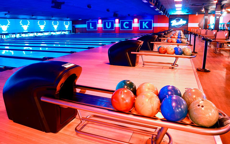 Bowling ball return with bowling lanes and Bowlero signs in the background