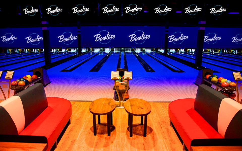 Bowling lane seats with bowling lanes and Bowlero signs in the background