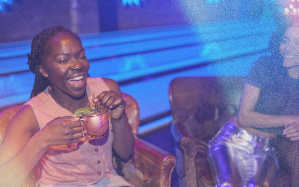 Woman drinking from a copper cup and laughing