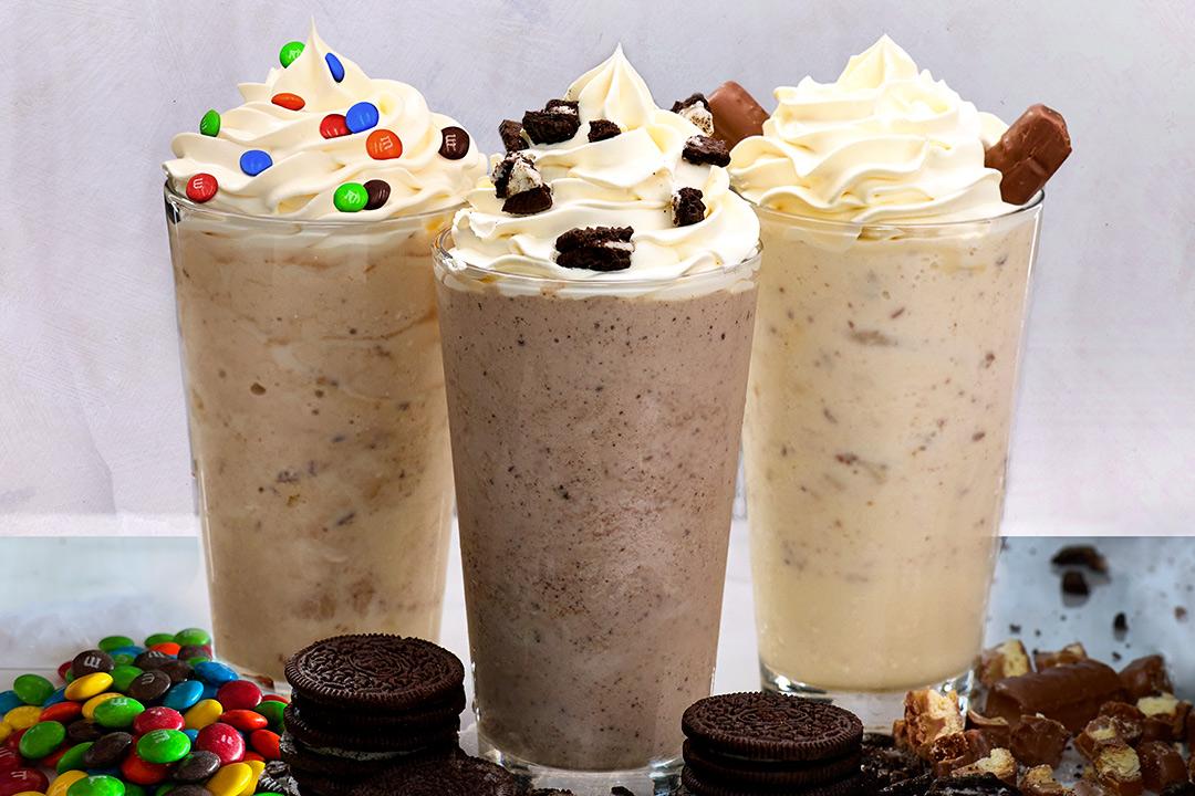 Three milkshakes in a row with candy. 