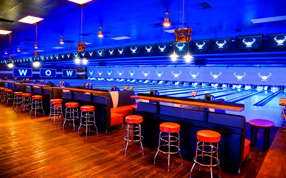 Black-lit bowling lanes and eating tables 