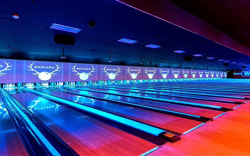 Bowling lanes with Bowlero signs in the background