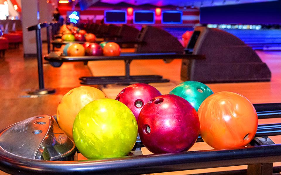 Colorful bowling balls lined up on return