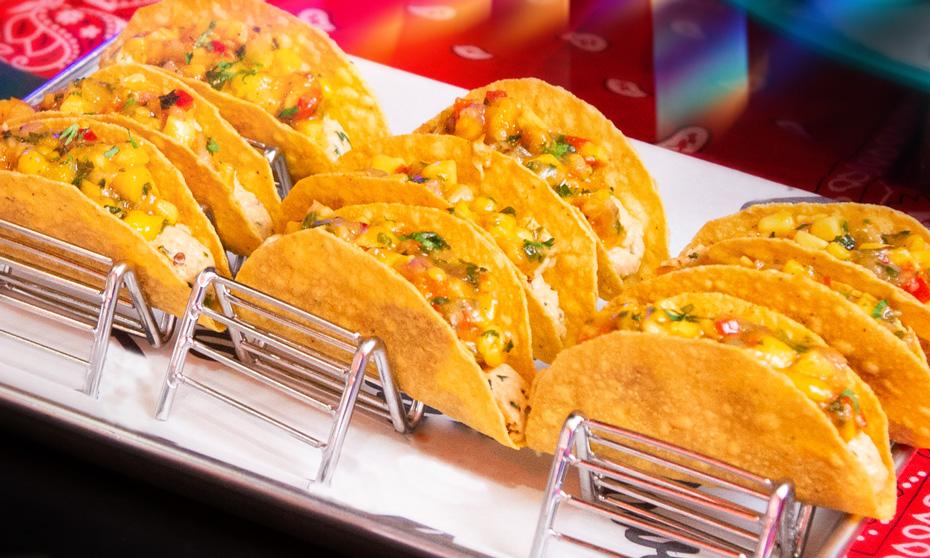 Mini chicken tacos displayed in a row. 