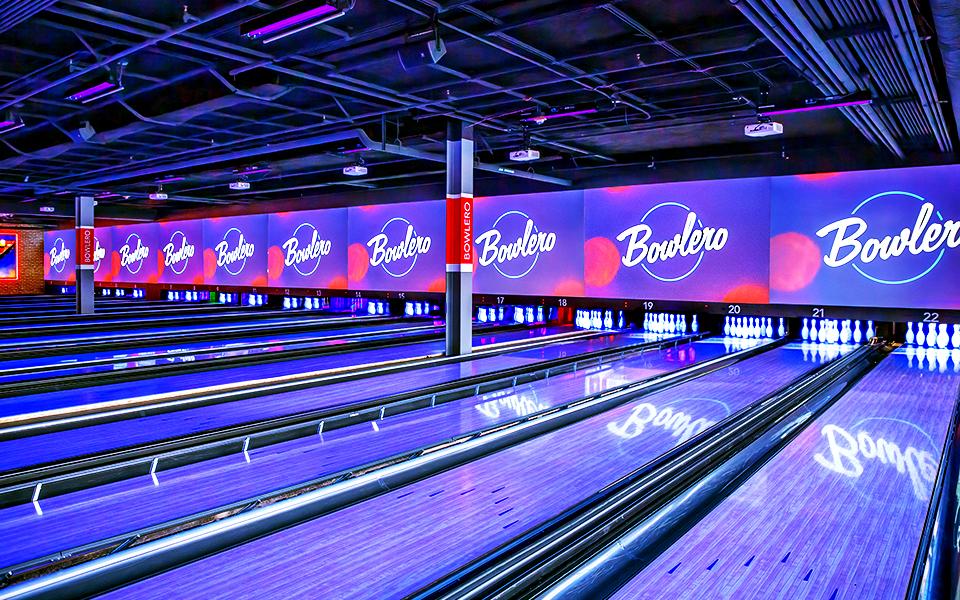 Beautifully lit bowling lanes with Bowlero signs