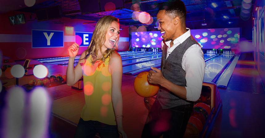 Two people smiling and having fun at a bowling center